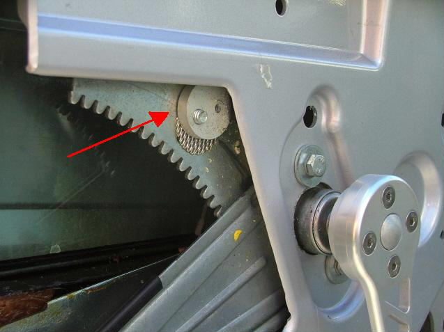 The adjustment disc and its bolt marked with a red arrow, next to the geared window regulator