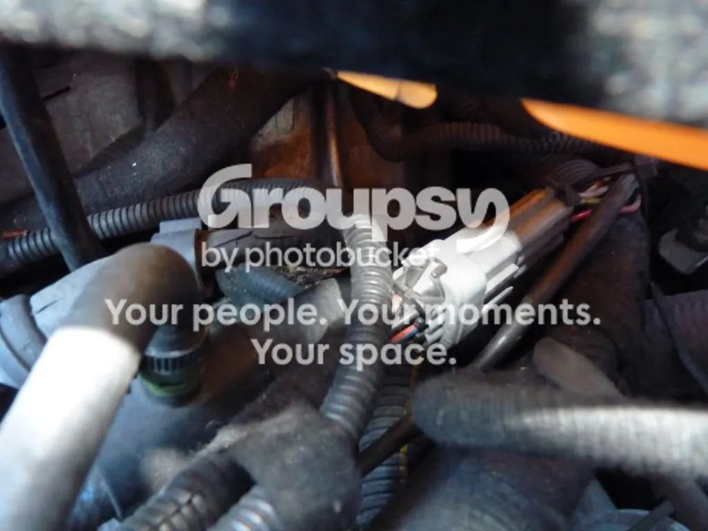 A third view of the engine end, with a white pipe and an electrical connector nearby
