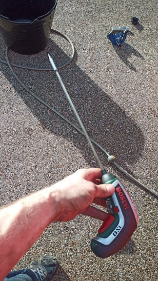 A hose running to a bucket on the ground