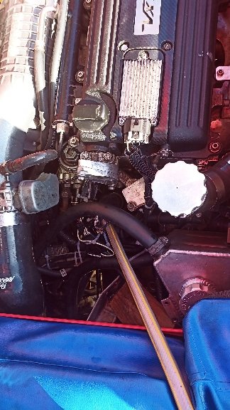 A hose pushed into the header tank outlet hose in the engine bay