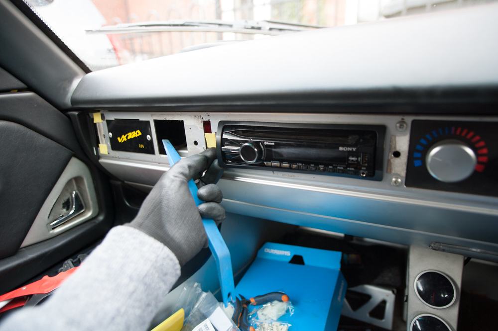 Popping the fascia off the radio cage with the trim tool