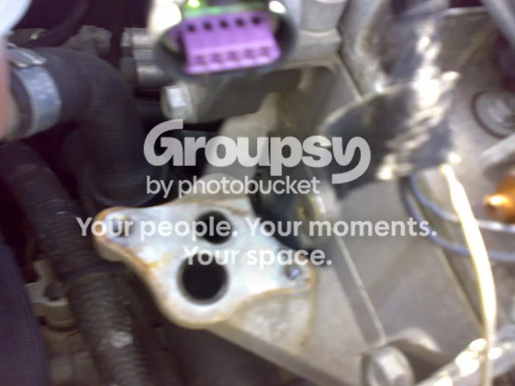 The mounting face on the engine with two round ports and the purple connector above