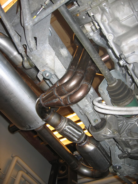 Underside view of the car showing the same style of header fitted, with a flexi section, a cat and a silencer on the left