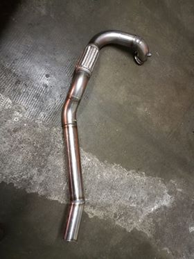 A stainless steel 3 inch downpipe with a flexi section and a flange, laid on a workshop floor