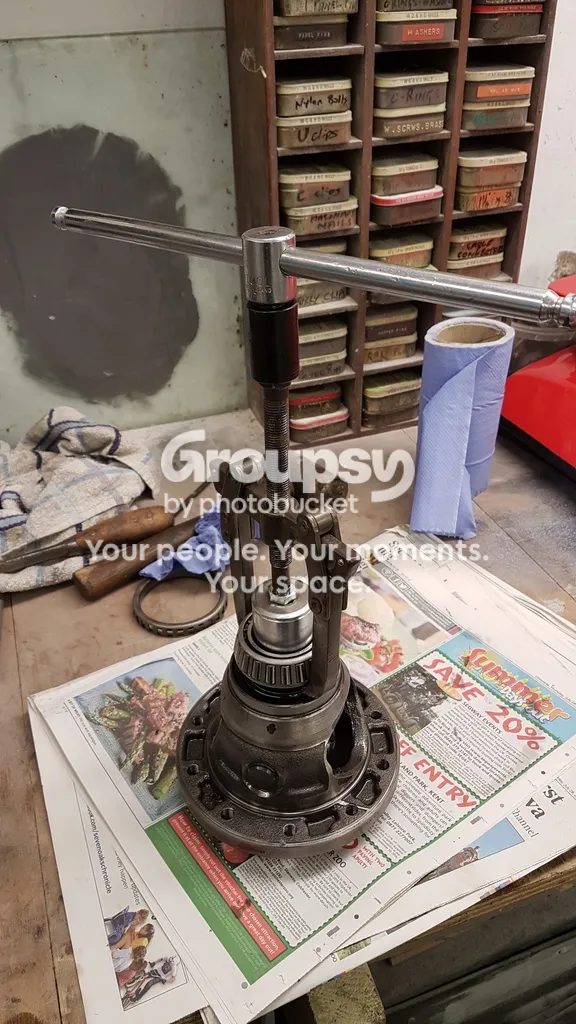 A diff standing on a bench with a bearing puller and ratchet on top