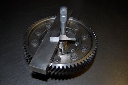 A crown wheel lying flat with a depth micrometer on a steel parallel across its face