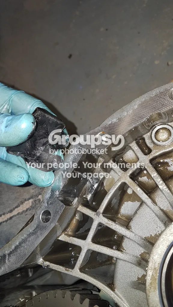 A gloved hand holding the magnet lifted out of the case