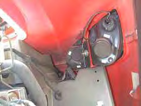Headlamp unit seen from inside the wheel arch, with its wiring