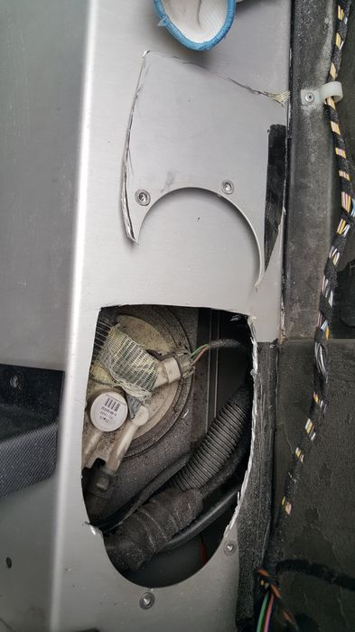 The enlarged opening with the pump and filler hose visible
