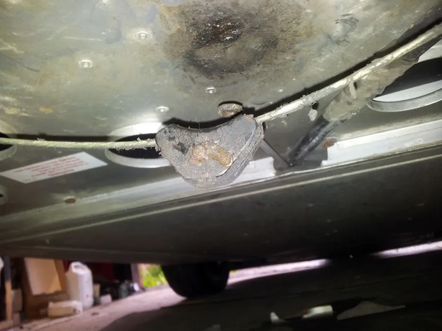 The underside of the floor with the handbrake cable and yoke