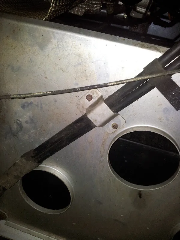 The cable support bracket under the floor with the gear cables