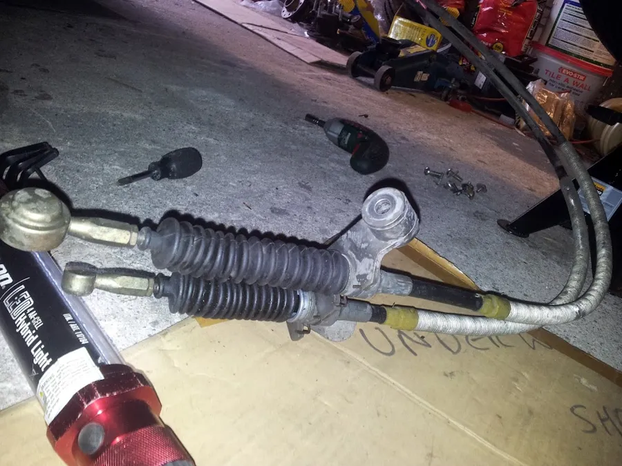 The gear cables and gearbox bracket lying on cardboard