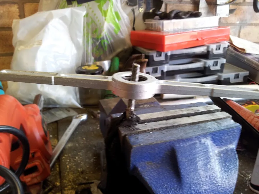 A die in a vice cutting a thread on a rod end