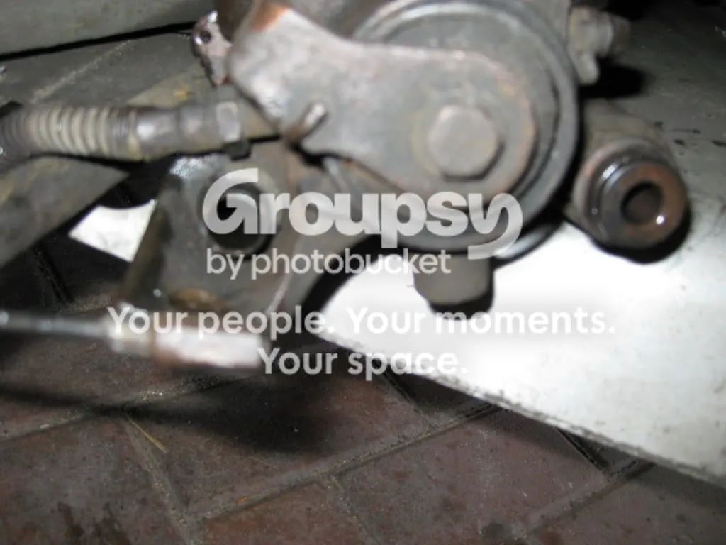 The rear caliper and handbrake lever with the cable end beneath it