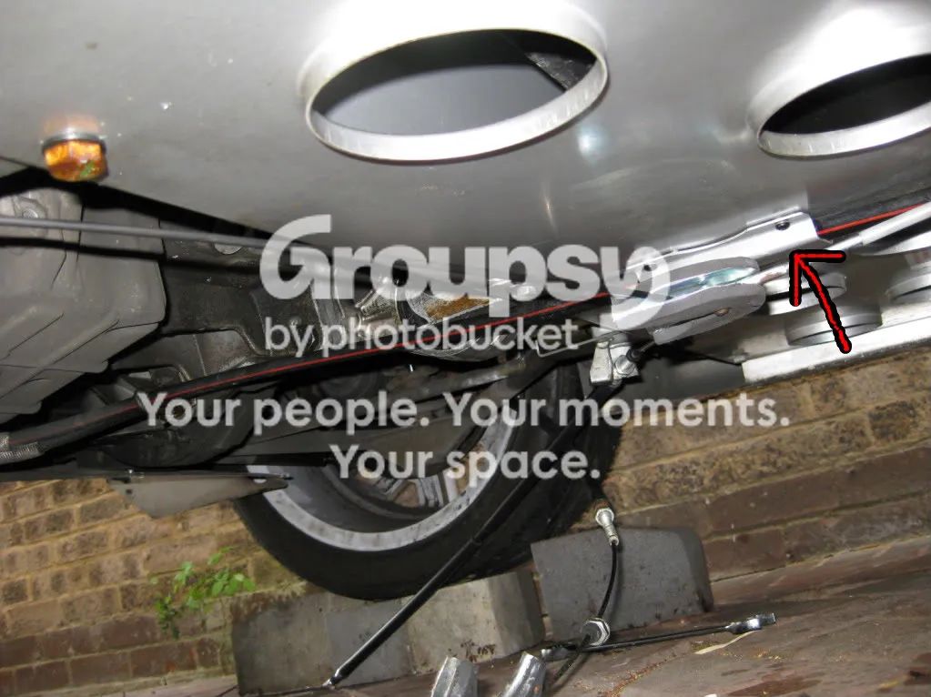 The underside of the car with a red arrow pointing to the tunnel where the foam goes