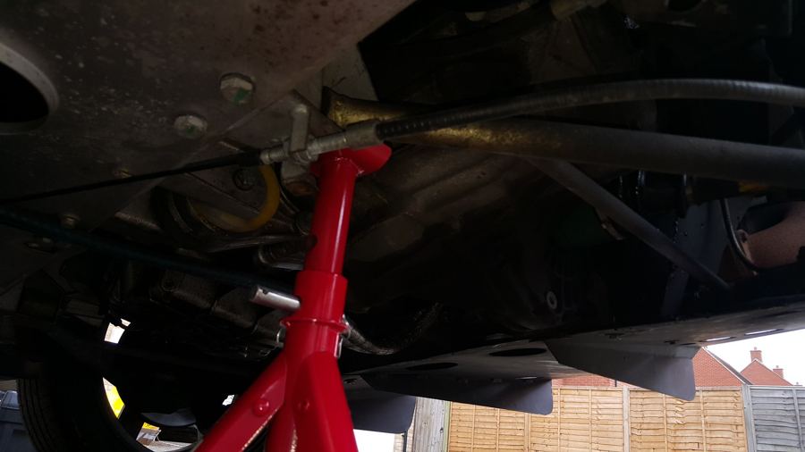 Underside of the car with a red axle stand in place
