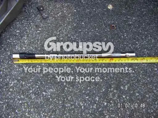 A long extension bar with socket laid next to a tape measure