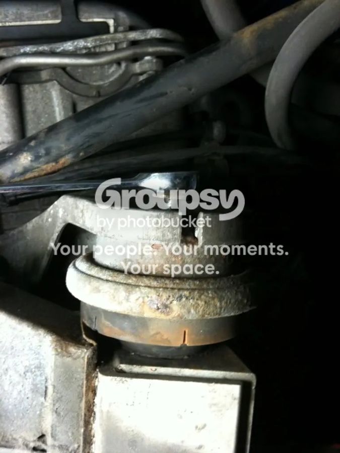 The off-side engine mount from underneath with a spanner on the top nut