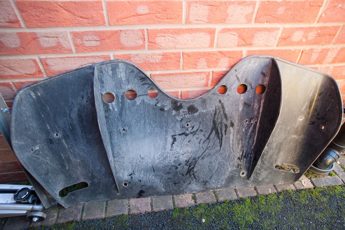 The black plastic diffuser leaning against a brick wall after removal