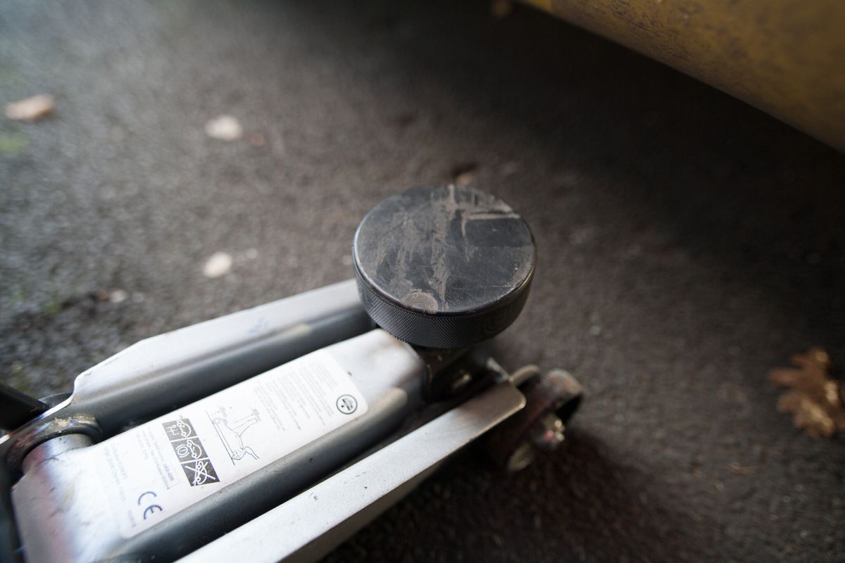 A trolley jack with a black hockey puck on its pad
