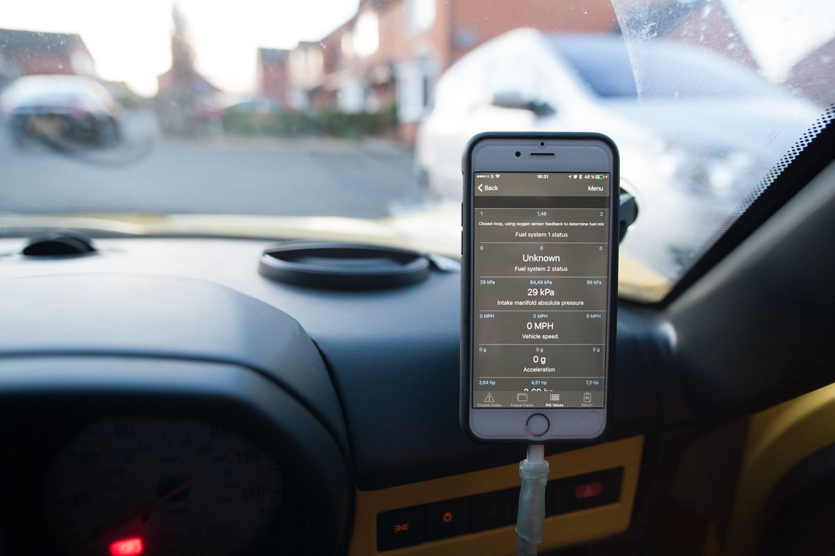 A phone showing an OBD app, mounted on the dashboard