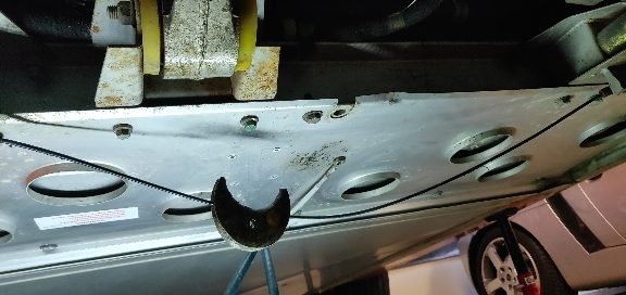 Underside of the tank with handbrake cable and bracket