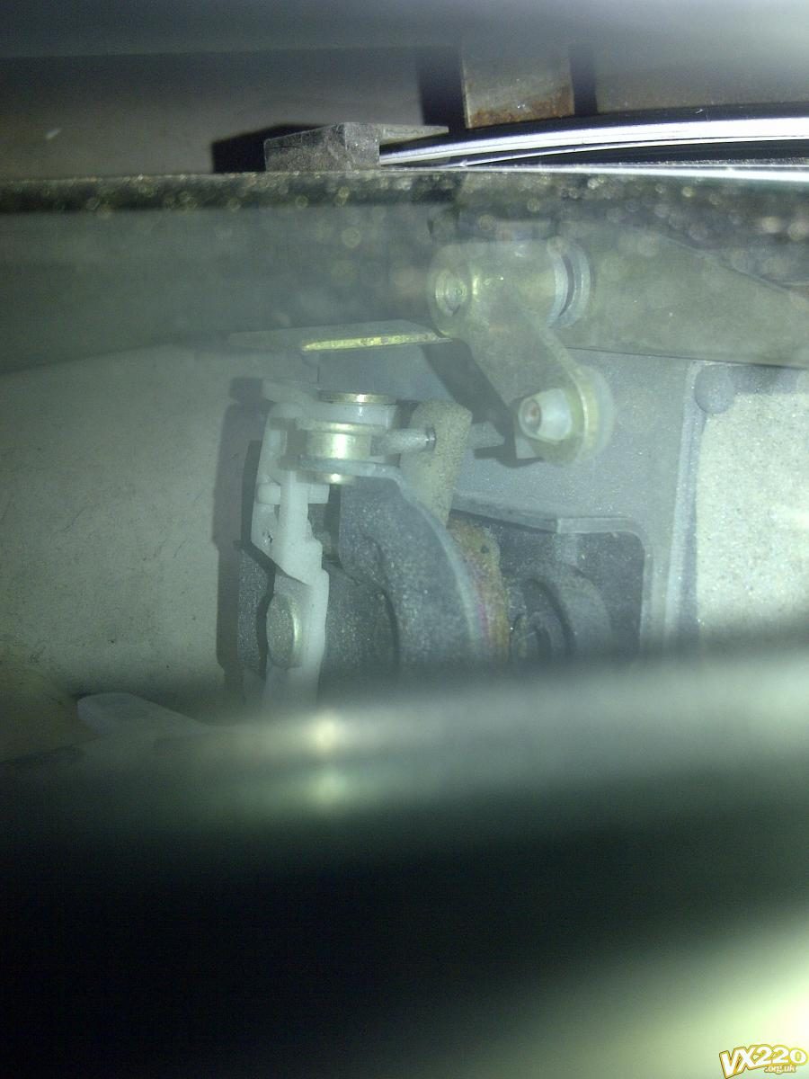 Looking down inside the door at the white plastic blocks and the adjuster at the bottom of the window glass
