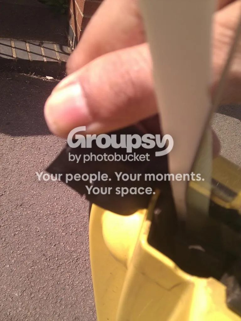 Close-up of a thumb and finger holding the backing strip as it comes away from the window edge