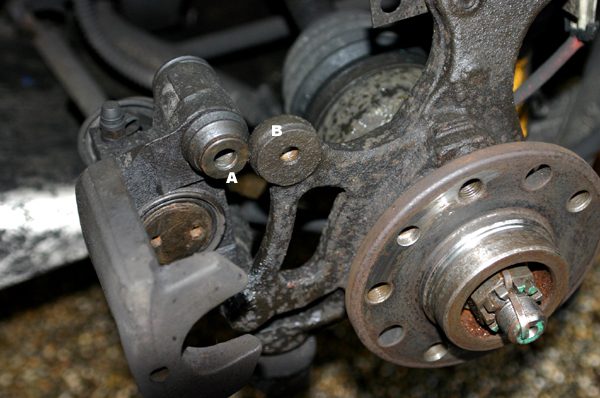 The rear caliper with the bolt barrel marked A sitting in a cup in the mounting marked B