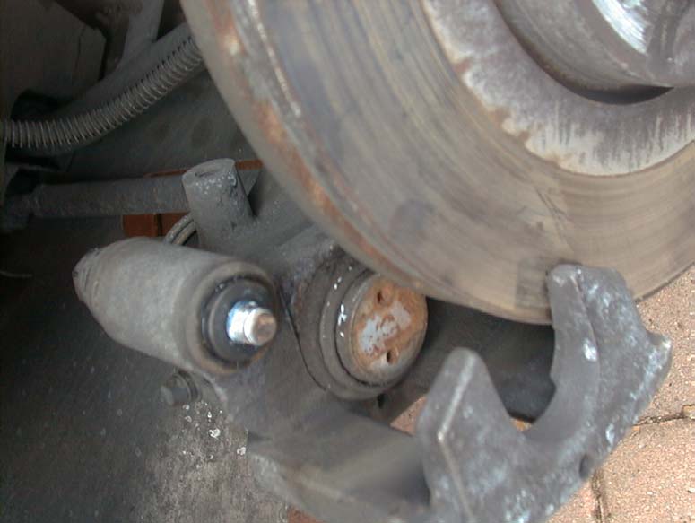 A closer view of the rear caliper leaned back, showing the mounting underneath