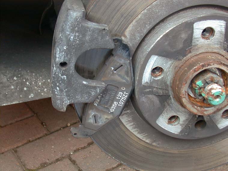 The outer pad being lowered out of the rear caliper next to the disc