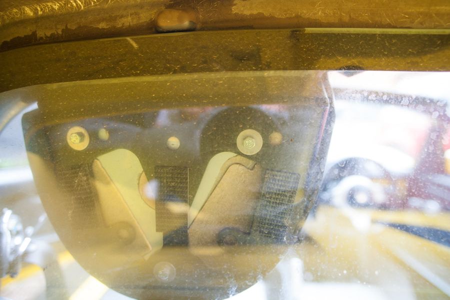 Behind the headrest, with three screws