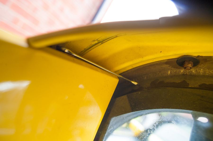 The 8 mm nyloc nut at the corner of the roll bar cover