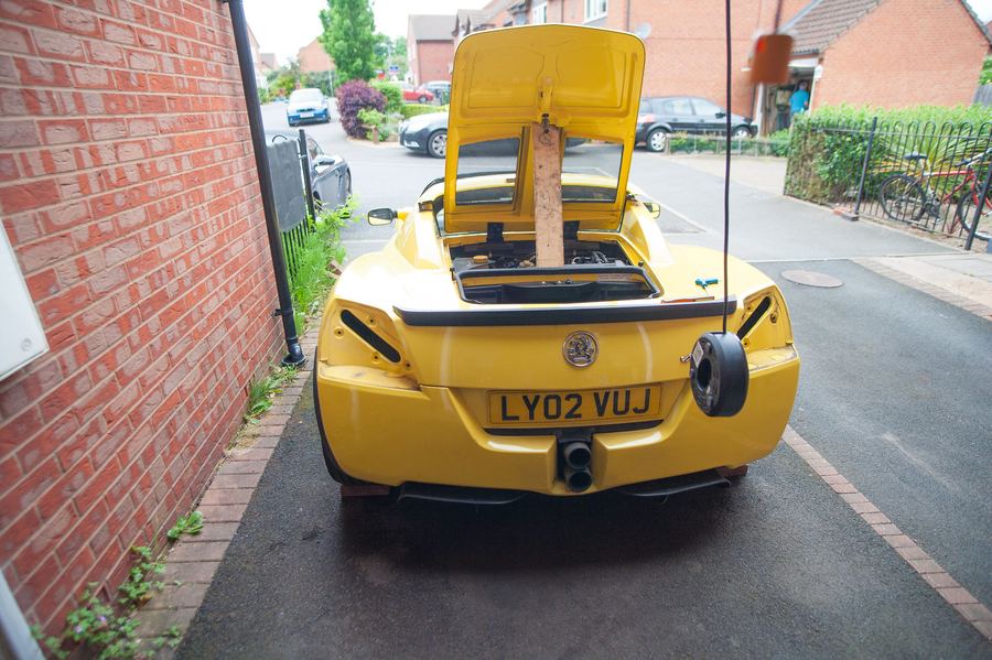 The rear of the car raised, with a stand under it
