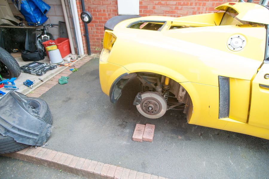 The side of the car on stands with the wheel off
