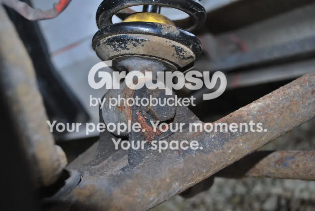 The base of a front shock and coil spring sitting on the lower wishbone