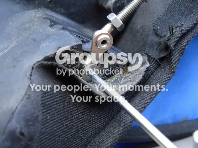 The cable end bolted to the end plate after threading, with the fabric flap folded back