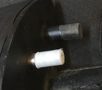Two spigots, one with a white HDPE tube cap and one with the original dark nylon
