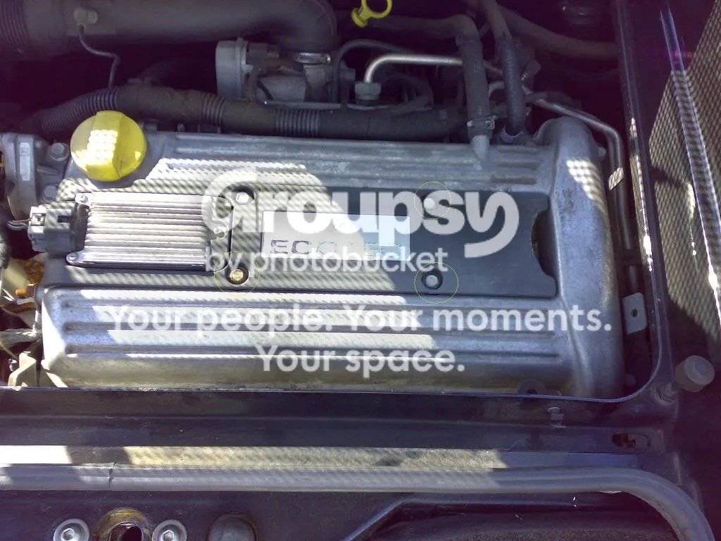 The top of the engine with the cam cover and the coil pack across it