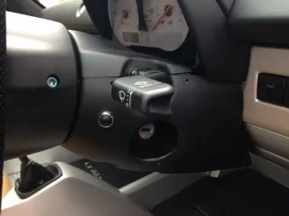 The steering column and indicator stalk seen from the side, with a blue-headed bolt on the steering wheel hub