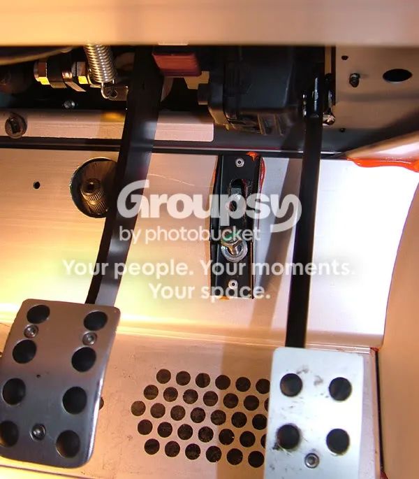 The footwell with pedals and the rack bracket and bolt in the middle