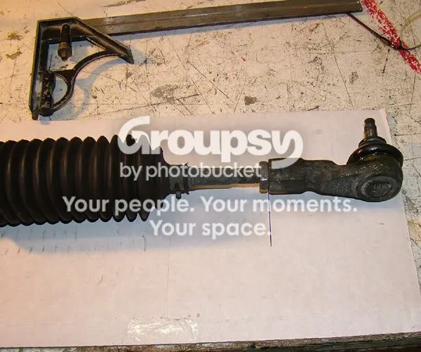 The track-rod end and gaiter on the cardboard, with a line drawn down from the square
