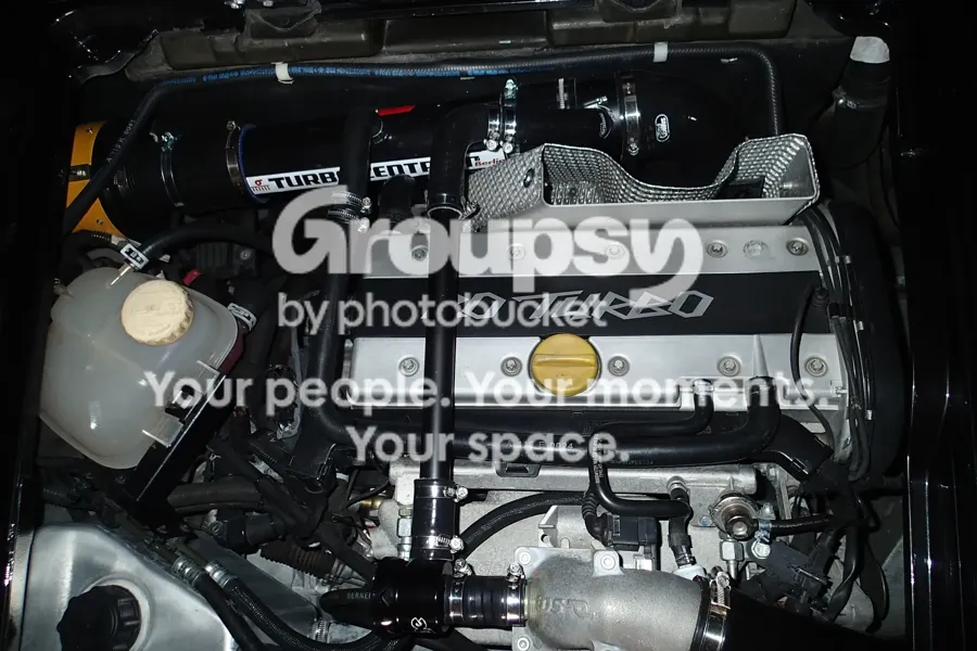 A Turbo engine bay with a black Forge-style valve and silicone hoses near the inlet manifold