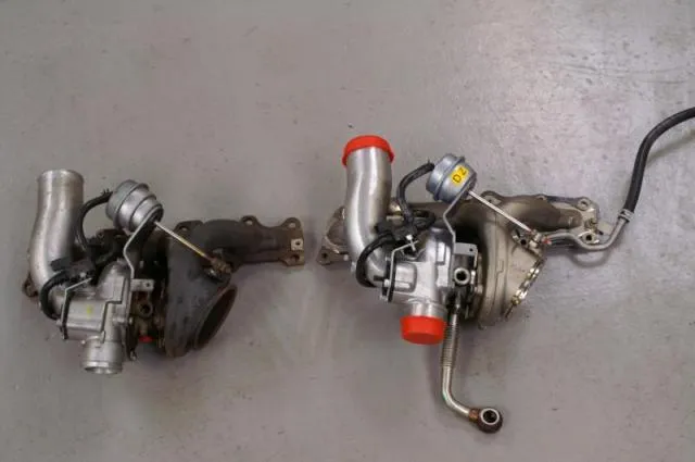 The two turbos side by side on a floor, the standard one on the left and the VXR unit on the right with a pipe attached