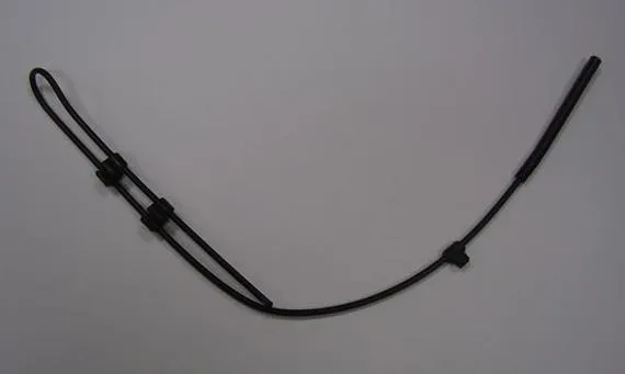 A thin black plastic tube with small holes, looped and held with cable ties, on a grey background
