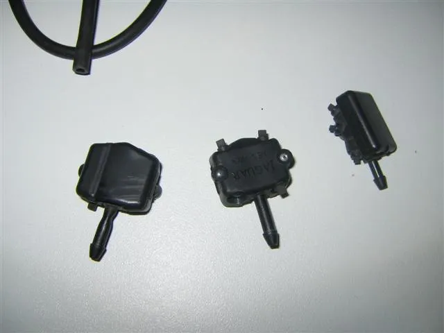 Three small black plastic washer jets with hose spigots, on a white background